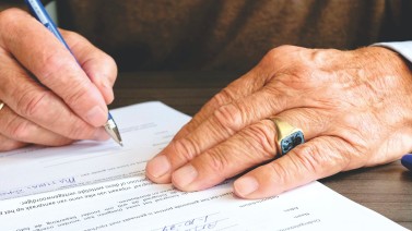 Close up of a person signing a paper