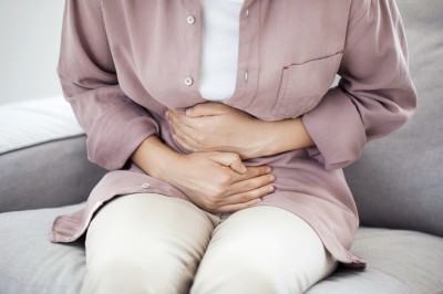 Woman holding stomach due to abdominal pain